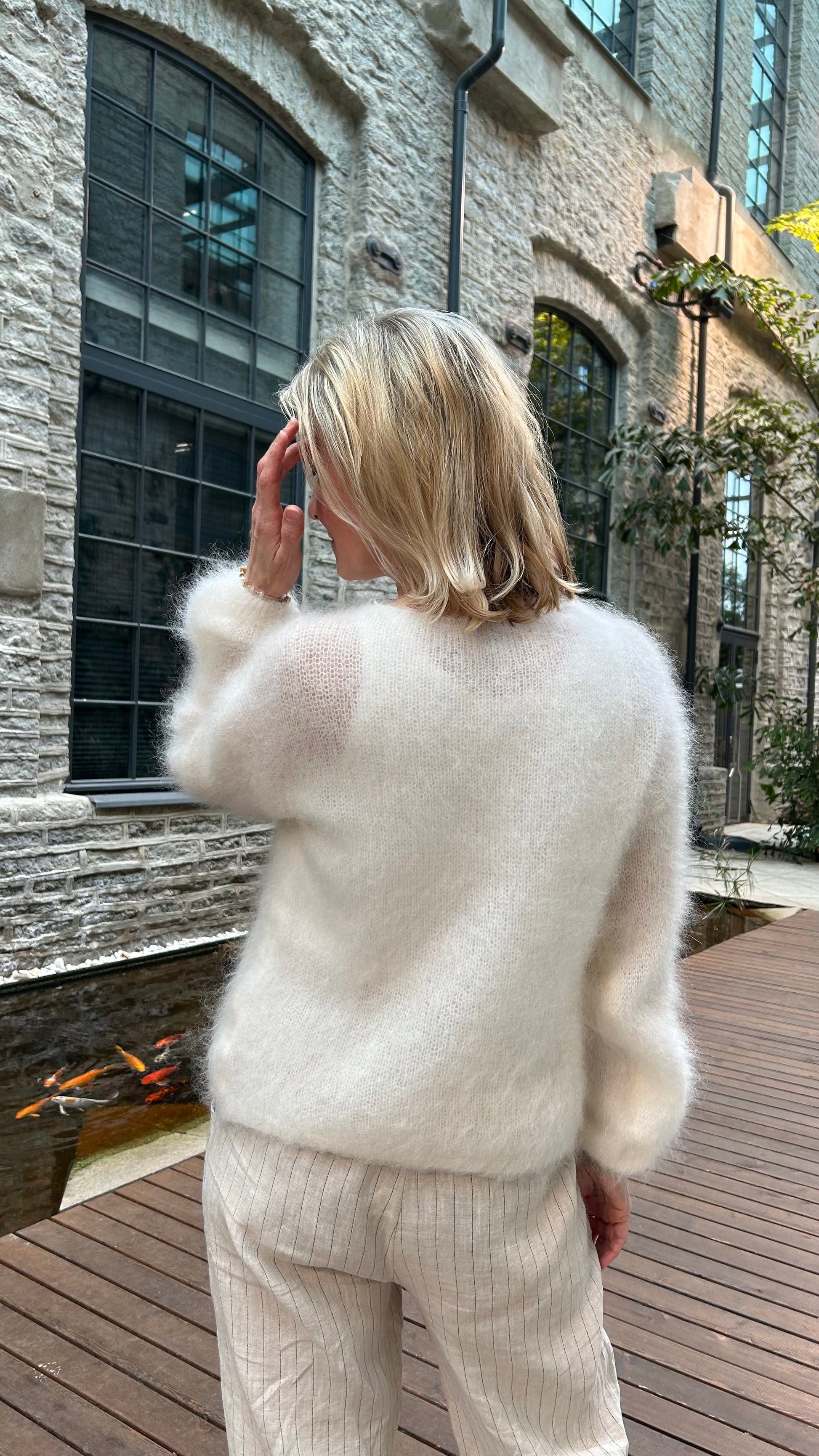 Women wearing off-white kid mohair cardigan from the back.