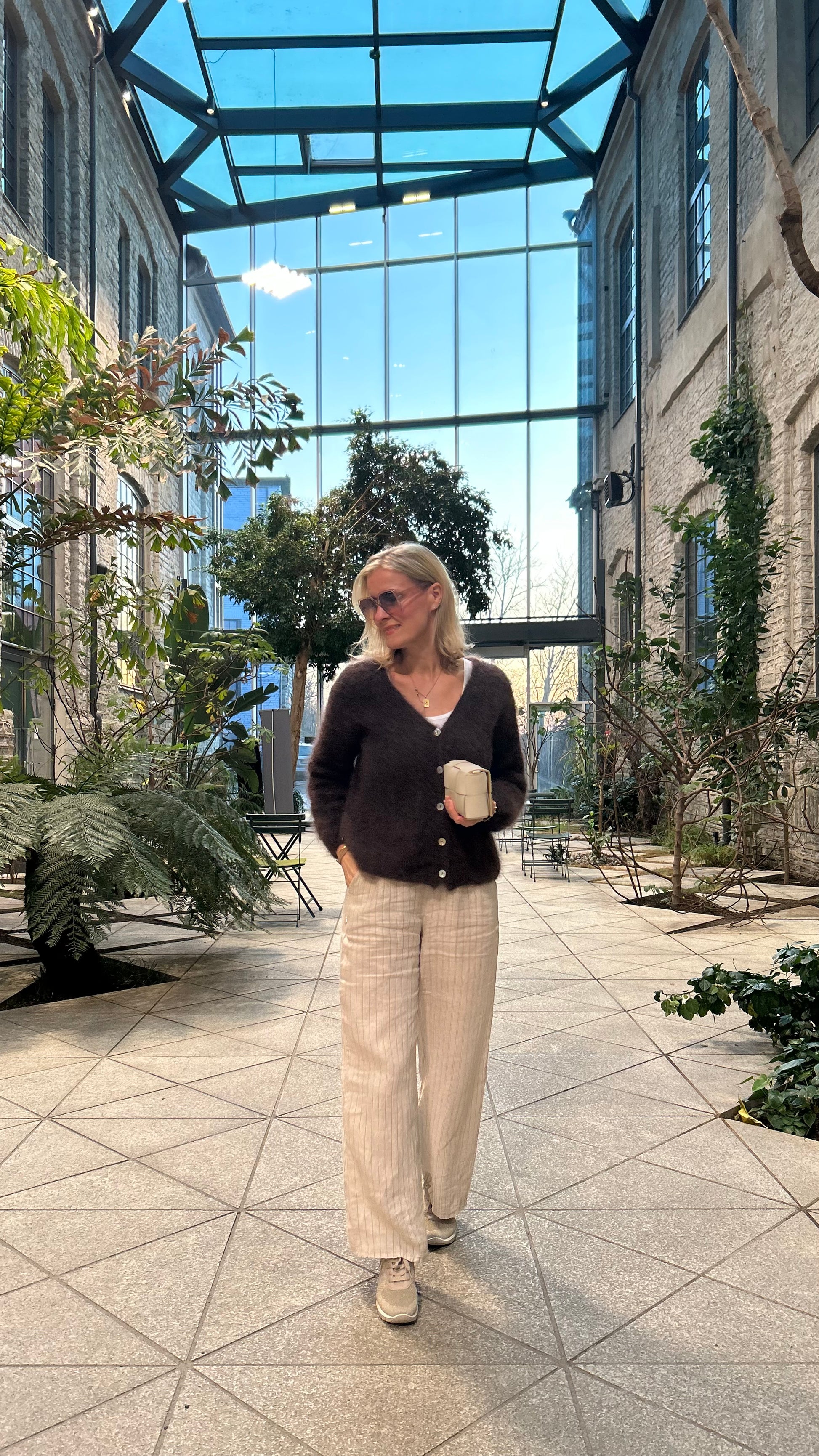 Women wearing brown kid mohair cardigan with beige linen pants.